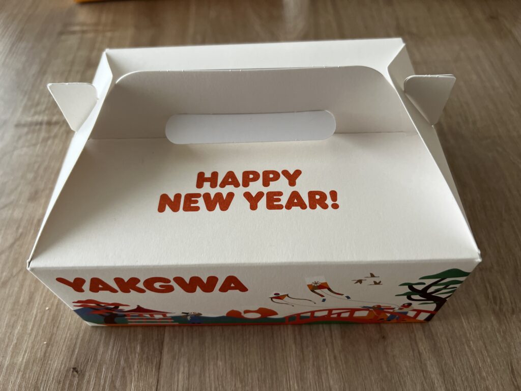 ダンキンドーナツ24個入りの箱（YAKGWAと書かれた持ち手つきの白い箱）