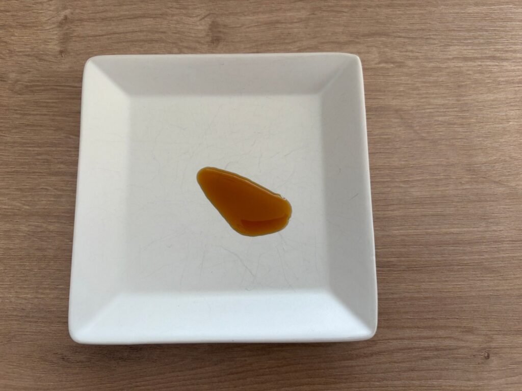 白い皿にたらした鎌田のだし醤油。濃口醤油より明るく、薄口醤油に近い色をしている