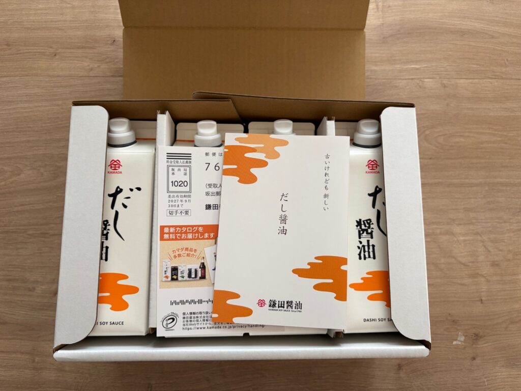 鎌田のだし醤油の箱を開けたところ。紙パックの上にだし醤油のレシピが載った冊子が入っている