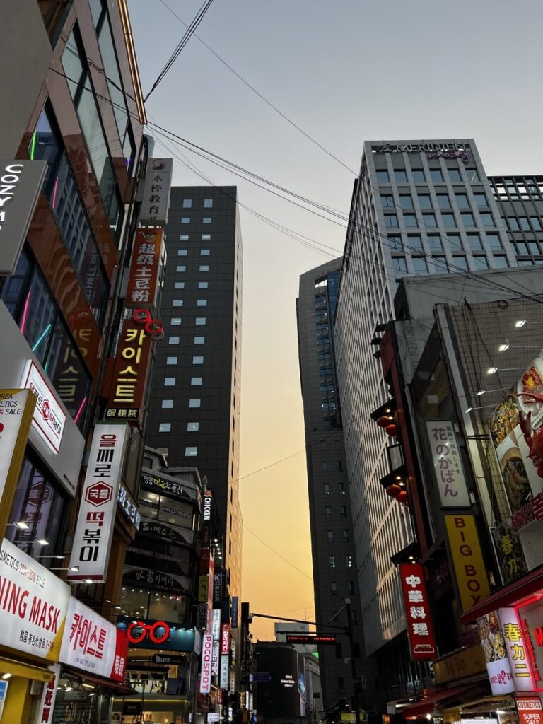夕暮れの明洞の通りに並ぶ韓国語の看板